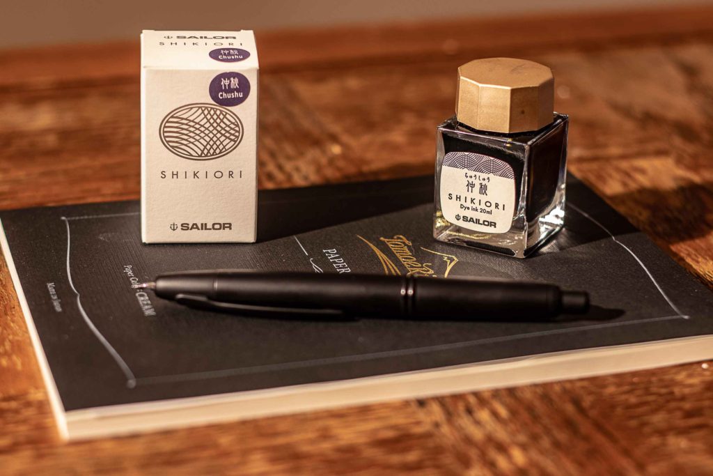 Le flacon et l'emballage de l'encre Chushu de la gamme Shikiori de Sailorl, Pilot Capless noir mat et paper pad Tomoe River.